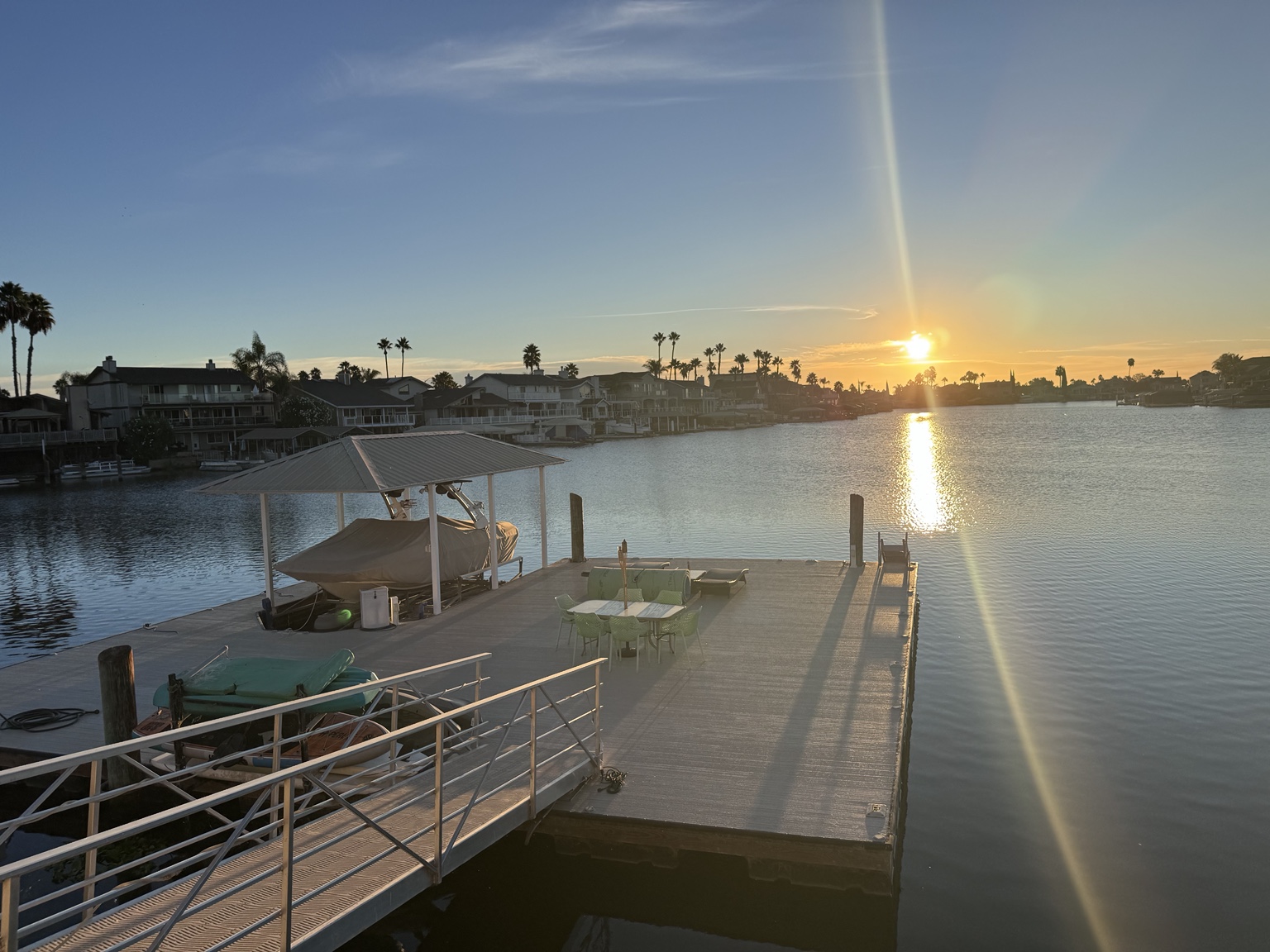 Golden sunlight reflecting across the water beside a dock in Discovery Bay